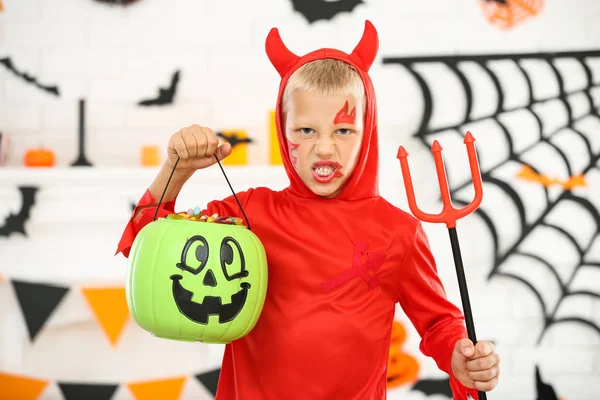 Giovane ragazzo in costume di Halloween che tiene secchio di zucca con candi — Foto Stock
