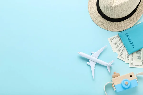 Model samolotu z paszportem, kapeluszem, banknotami dolarowymi i kamerą t — Zdjęcie stockowe
