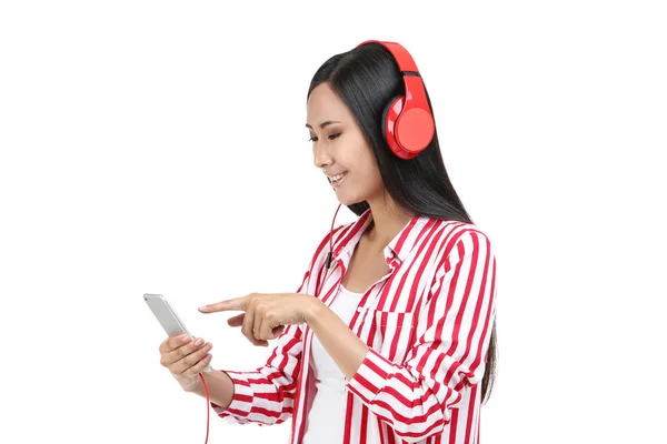 Hermosa mujer con auriculares y teléfono inteligente en backgrou blanco — Foto de Stock