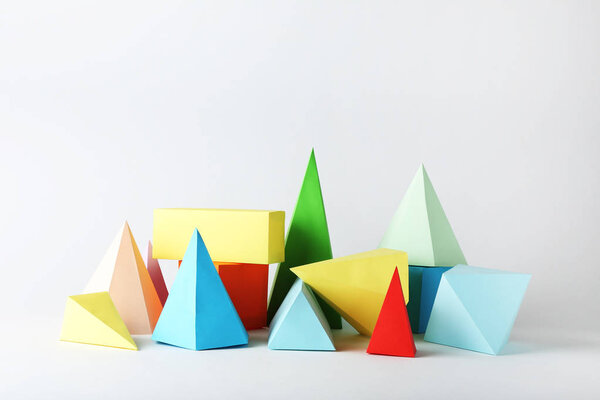 Цветные геометрические фигуры бумаги на сером фоне
