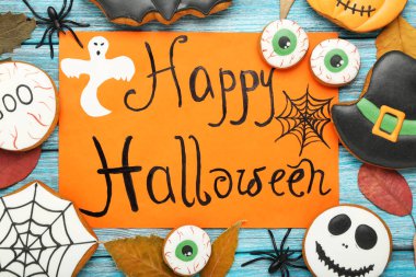 Üzerinde yazı olan zencefilli kurabiyeler Mavi ahşap sekmede Mutlu Cadılar Bayramı