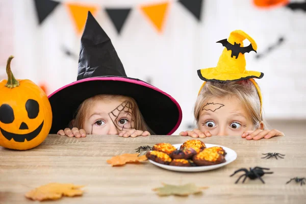 Jonge twee meisjes in Halloween kostuums op zoek naar de koekjes — Stockfoto