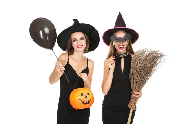 Deux jeunes femmes en costumes d'Halloween avec seau de citrouille et br — Photo