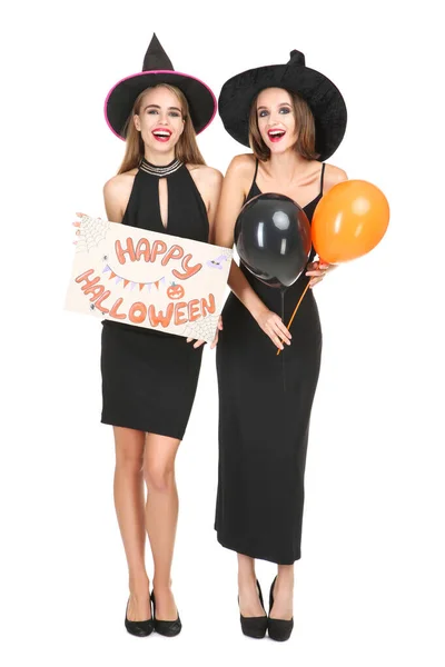 Дві молоді жінки в чорних костюмах тримають папір з текстом Щасливий — стокове фото