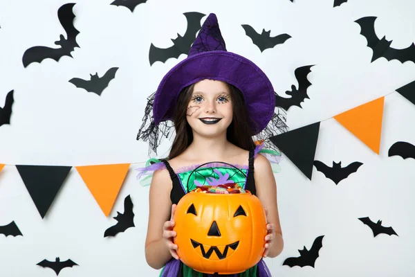 Mooi meisje in Halloween kostuum met pompoen emmer op wit — Stockfoto