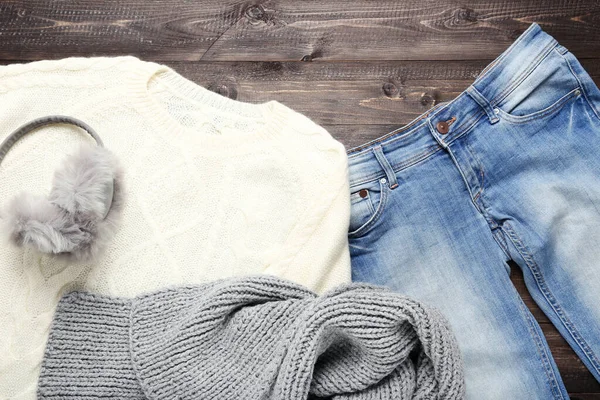 나무타기에 회색 스카프, 청바지, 귀마개가 달린 뜨개 질 스웨터 — 스톡 사진