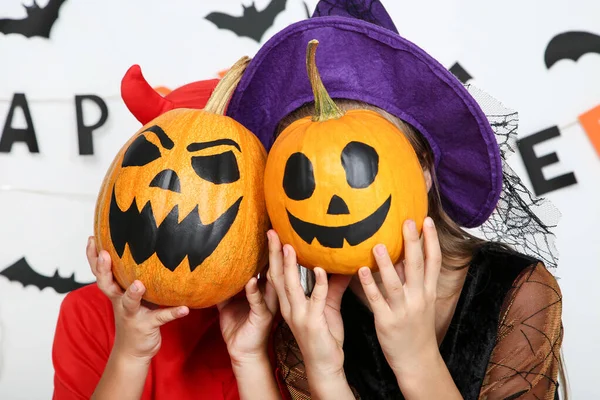 Menina e menino em trajes de Halloween com abóboras — Fotografia de Stock