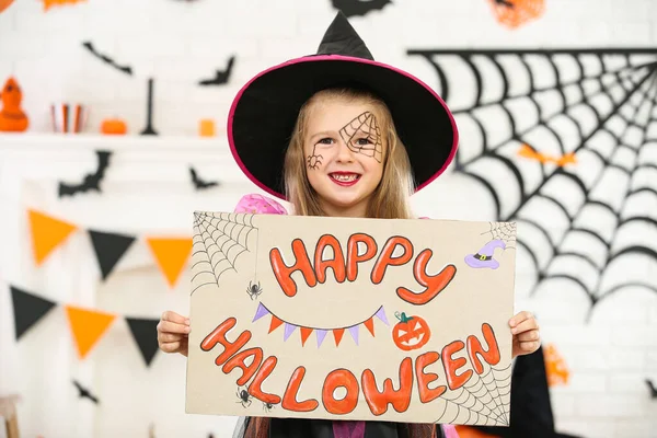 Chica joven en traje sosteniendo papel con texto Feliz Halloween —  Fotos de Stock