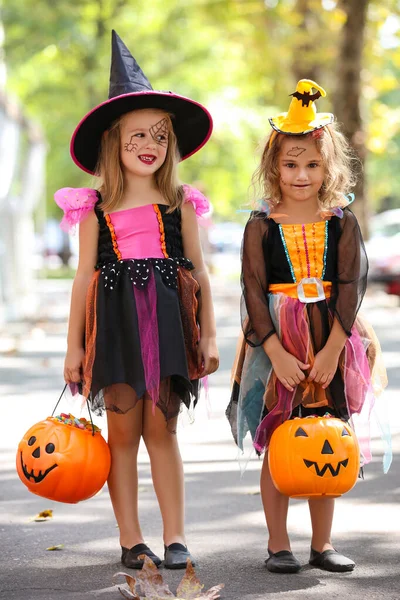 Jonge meisjes in Halloween kostuums met pompoen emmers — Stockfoto