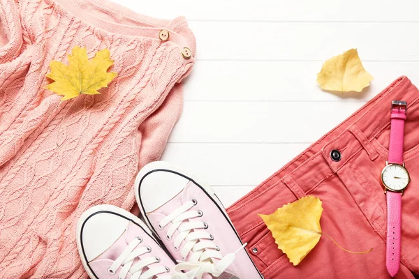 Jersey de lana con jeans, zapatillas de deporte y hojas de otoño en woo blanco —  Fotos de Stock