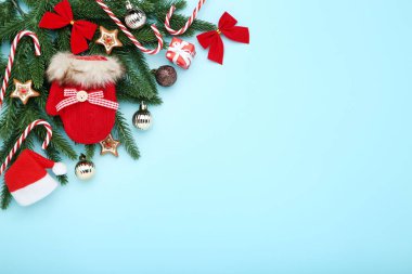 Mavi arka planda oyuncakları ve şekerlemeleri olan Noel ağacı dalları
