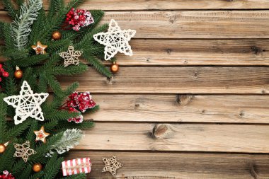 Oyuncak dolu Noel ağacı dalları ve kahverengi ormanlık alanda kırmızı meyveler