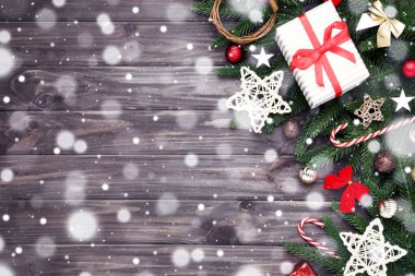 Noel ağacı dalları oyuncaklar ve hediye kutusu ahşap masada.