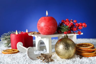 Tahta kızaklı, mücevherli ve kırmızı meyveli Noel mumları 