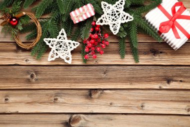 Noel ağacı dalları oyuncaklar ve kahverengi ahşap bir hediye kutusu.