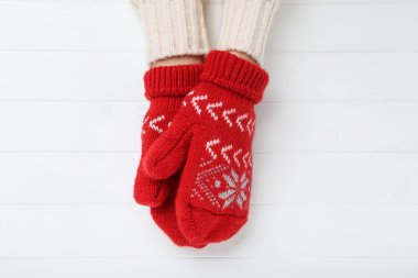 Eldivenli eller beyaz ahşap masada.