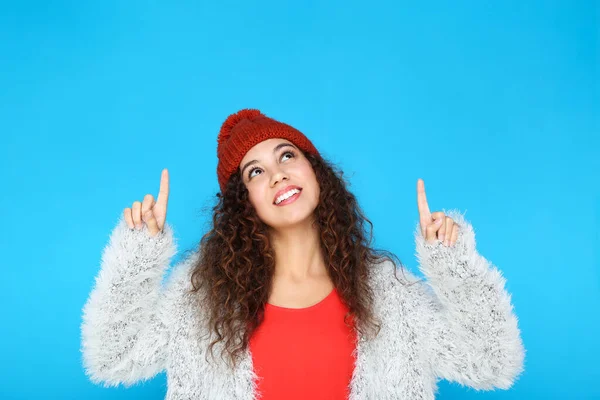 Mooie amerikaanse vrouw in mode kleding wijzend door vingers op blauwe achtergrond — Stockfoto