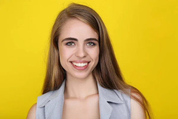 Joven chica sonriente sobre fondo amarillo — Foto de Stock