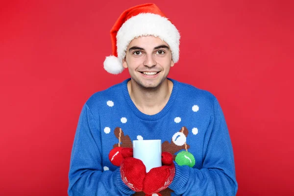 Красива людина в різдвяному светрі, капелюсі Санта, рукавичках і h — стокове фото