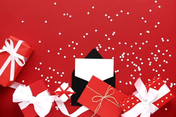 Paper envelopes with gift boxes on red background