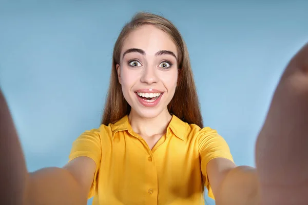 Menina bonita jovem fazendo selfie no fundo azul — Fotografia de Stock