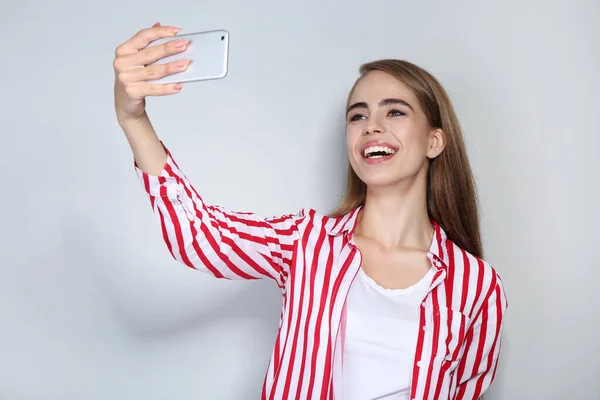 Joven hermosa chica haciendo selfie en el teléfono inteligente — Foto de Stock