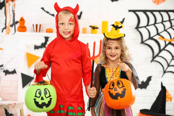 Chica joven y niño en trajes de halloween con cubos de calabaza —  Fotos de Stock