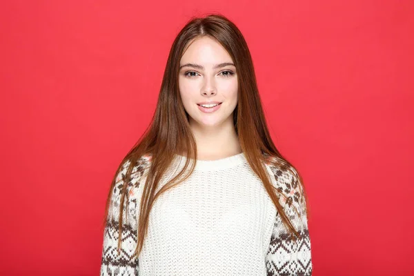 Beautiful woman in sweater on red background