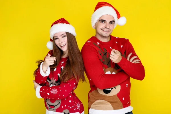 Hermoso hombre y mujer en suéteres de Navidad y sombreros de santa en —  Fotos de Stock