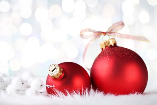 Palline rosse di Natale con fiocco a nastro su sfondo sfocato — Foto Stock