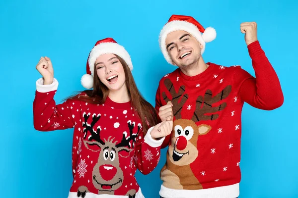 Hermoso hombre y mujer con suéteres de Navidad y sombrero de santa —  Fotos de Stock