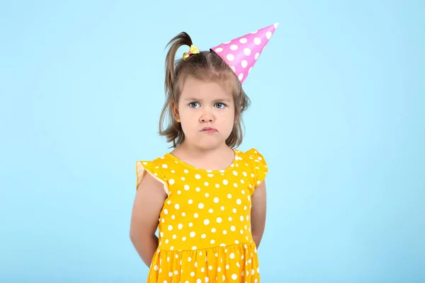 Cute Little Girl w czapkę urodzinowa na niebieskim tle — Zdjęcie stockowe