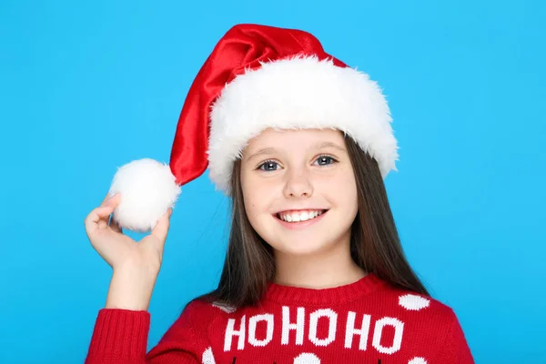 Menina em camisola de Natal e chapéu no fundo azul — Fotografia de Stock