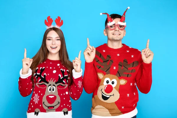 Bonito homem e mulher vestindo camisolas de Natal com chifre vermelho — Fotografia de Stock