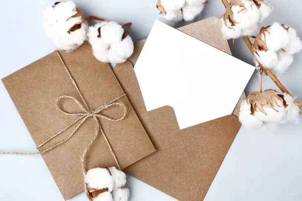 Paper envelopes with cotton flowers on grey background — Stock Photo, Image