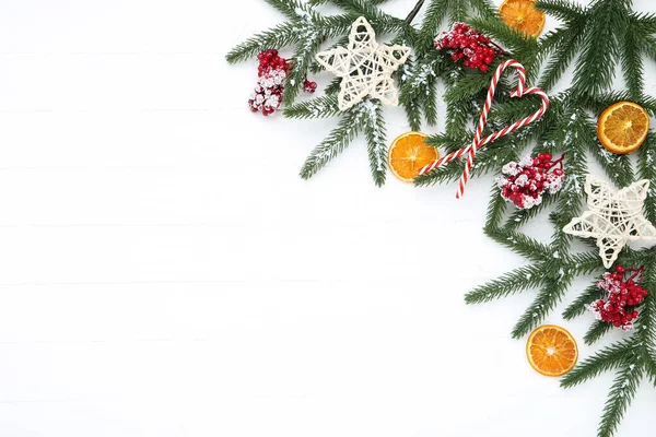 Rami di albero di Natale con bacche rosse, caramelle e fru arancio — Foto Stock