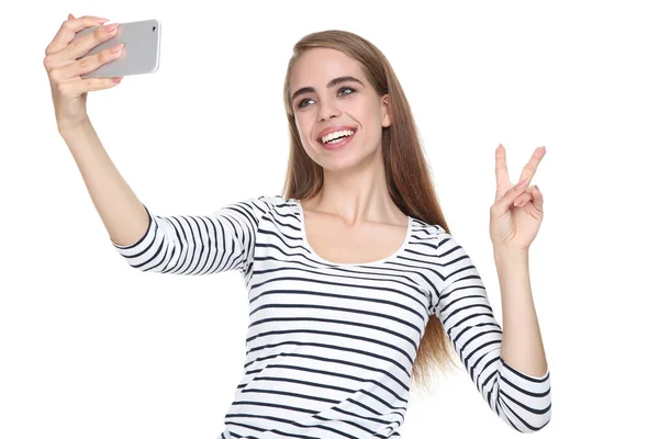Молодая красивая девушка делает селфи на смартфоне — стоковое фото