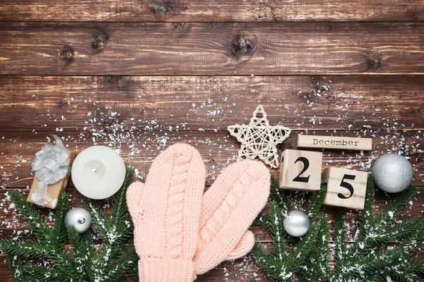 Knitted mittens with fir tree branches, calendar and baubles on — Stock Photo, Image