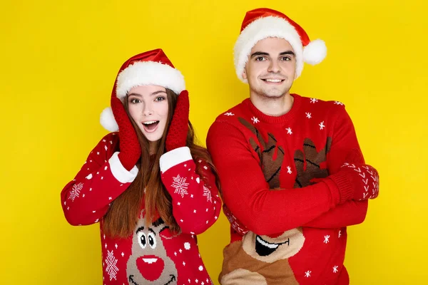 Красивий чоловік і жінка в різдвяних светрах і капелюхах Санти на — стокове фото