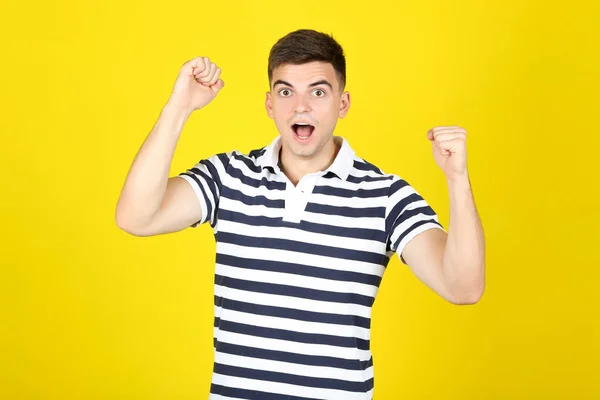 Jonge verraste man op gele achtergrond — Stockfoto