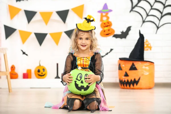 Молодая девушка в костюме Хэллоуина держит ведро с тыквой с песком — стоковое фото