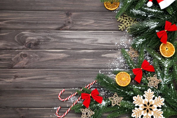 Christmas tree branches with toys and orange fruits on wooden ta — Stock Fotó