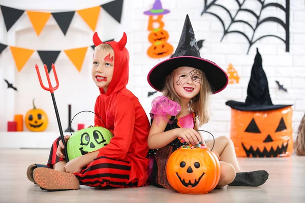 Chica joven y niño en trajes de halloween con cubos de calabaza —  Fotos de Stock