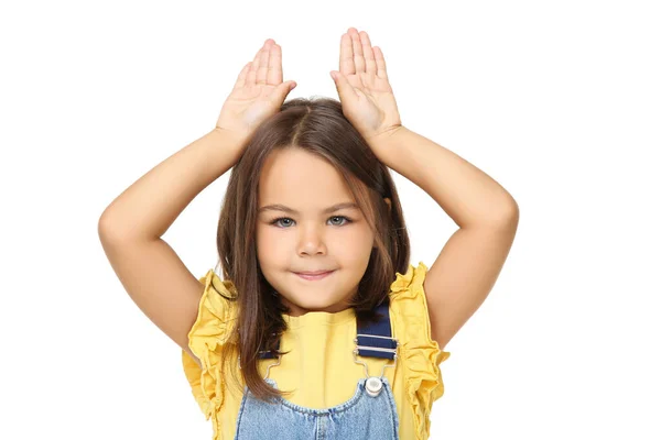 Красива маленька дівчинка показує вуха руками на білому тлі — стокове фото