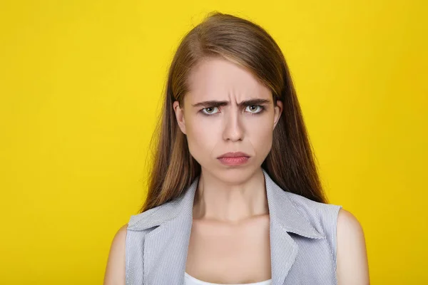 Joven chica triste sobre fondo amarillo — Foto de Stock