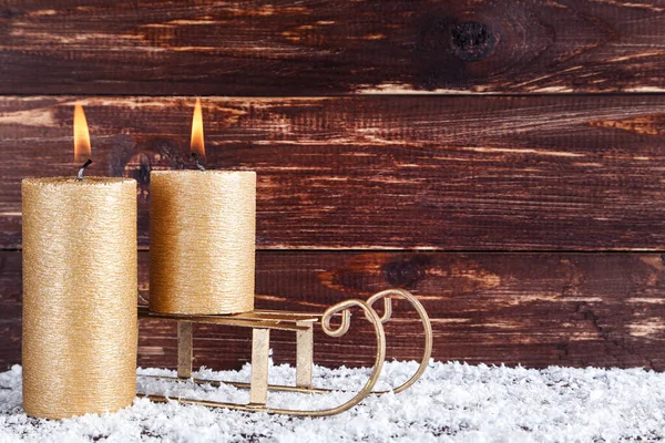 Рождественские свечи с санями на коричневом фоне — стоковое фото