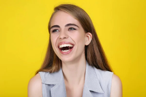 Jong lachen meisje op gele achtergrond — Stockfoto