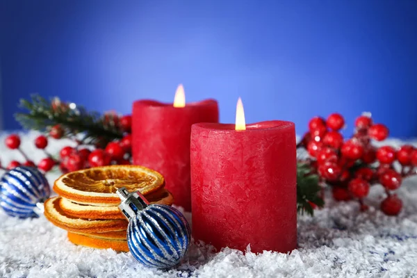 Рождественские свечи с сухими апельсинами, безделушками и красными ягодами на б — стоковое фото