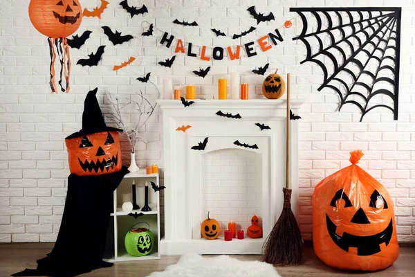 Halloween decoraties op witte open haard met oranje pompoenen — Stockfoto