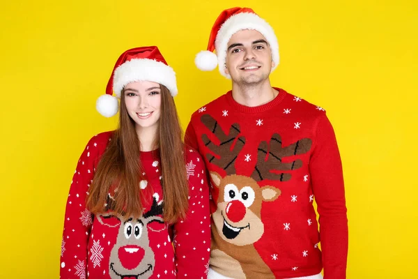 Homem e mulher bonita em camisolas de Natal e chapéus de Papai Noel em — Fotografia de Stock